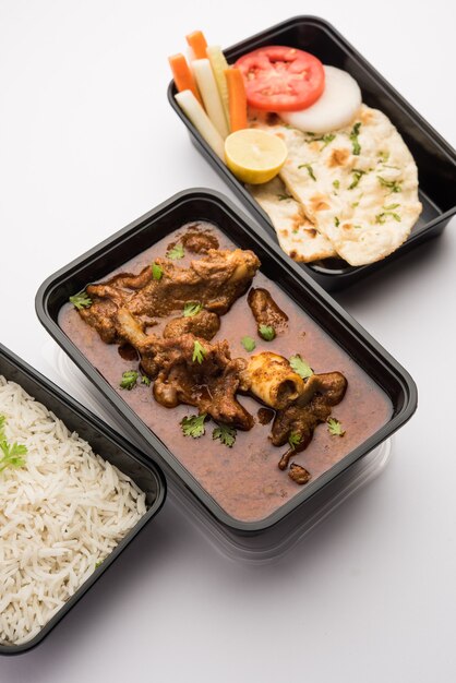 온라인 음식 배달 - 양고기 또는 Gosht Masala 또는 픽업 준비가 된 플라스틱 용기에 담긴 인도 양고기 로건 조쉬