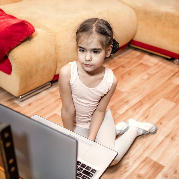 Online hobby, fitness, distant training. Young ballerina talking with dance classmates in internet after online ballet class at home, online education