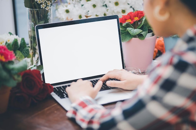 Concetto di composizione floreale domestica online donna asiatica fiorista sorridente registra trasmissione video o corso su smartphone o computer comporre organizzare decorazioni florealinegozio di fiori online