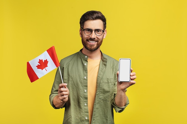 Online learning concept Happy man holding smartphone and Canada flag recommending mobile app mockup