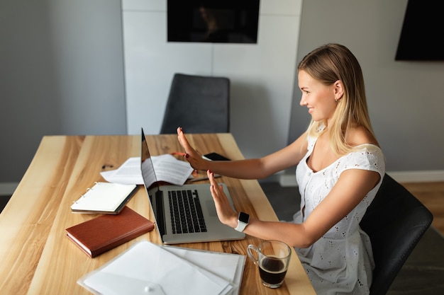 Foto apprendimento e lavoro online. videochiamata, videoconferenza con altre persone sul laptop al chiuso. donna con computer portatile che lavora in ufficio a casa