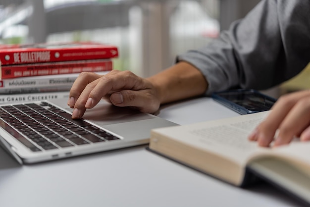 Online les leren door een laptopcomputer te gebruiken en een notitieboekje te schrijven op de werkplek Onderwijsontwikkeling of kennisverbeteringsconcept