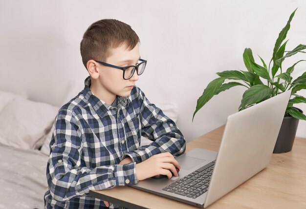 Online lesson at home, social distance during quarantine, self-isolation, online education concept, home schooler. Boy learning language online, using laptop, distance education. Student boy, school