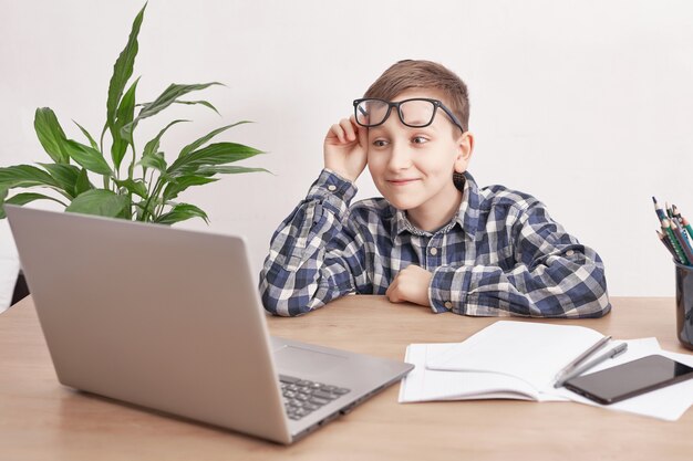 Online lesson at home, social distance during quarantine, self-isolation, online education concept, home schooler. Boy learning language online, using laptop, distance education. Student boy, school