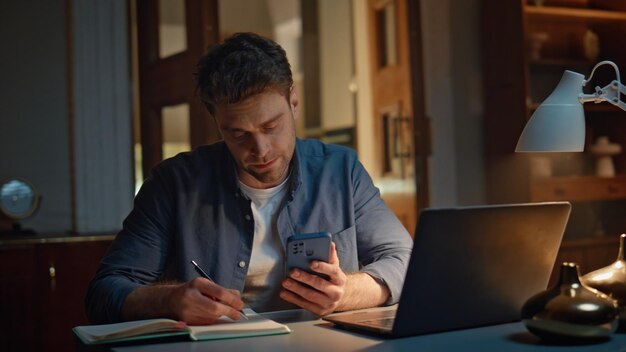 Online manager writing notes at late home closeup calm man videocalling laptop