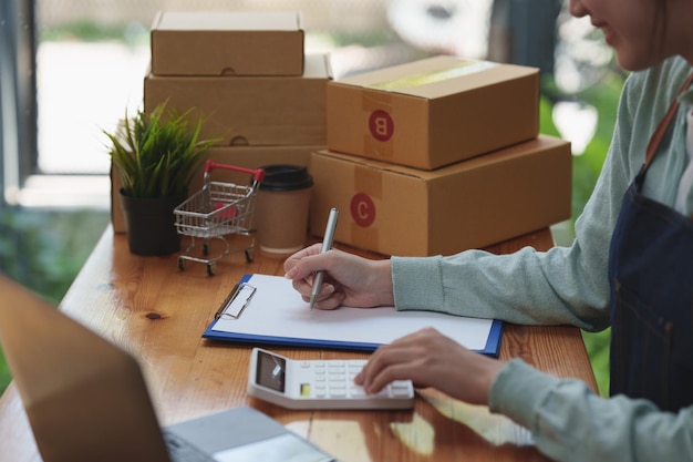 オンラインマーケティングパッキングボックス配信コンセプトアジアの女性スタートアップ中小企業フリーランスと小包ボックスを顧客に配信する