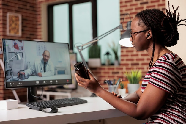 Online medisch consult, patiënt in gesprek met arts, bespreking van voorgeschreven medicijn. Telegeneeskunde, live communicatie met therapeut op computer, vrouw chatten met medic