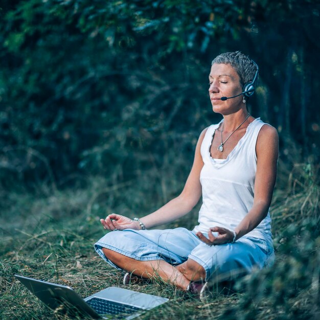 Photo online meditation personal development trainer meditating with her clients over the internet