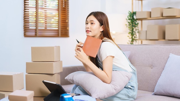 Online merchant concept Female entrepreneur relaxes after packaging product into parcel boxes