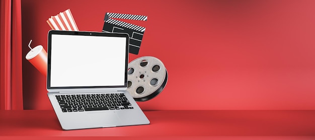 Online movie watching and cinematography concept with blank white modern laptop screen with place for your logo or text on empty red cinema background with popcorn and filmstrip 3D rendering mockup