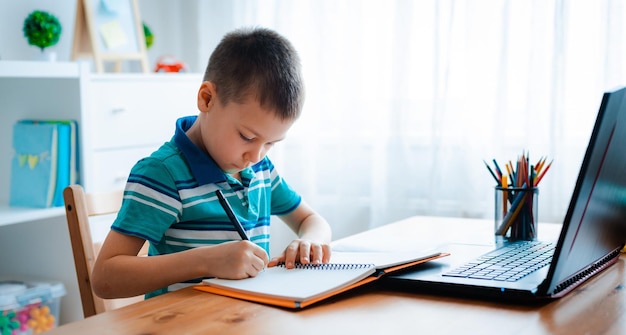 Online onderwijs op afstand Een schooljongen studeert thuis en maakt huiswerk op afstand Een thuisonderwijs op afstand