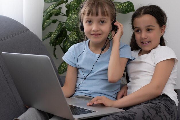 Online onderwijs op afstand. Een schoolmeisjes studeren thuis en maken huiswerk op school. Een thuisonderwijs op afstand.