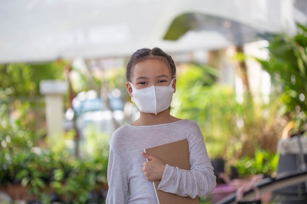 Online onderwijs op afstand. kind in een masker om een online les te kijken.