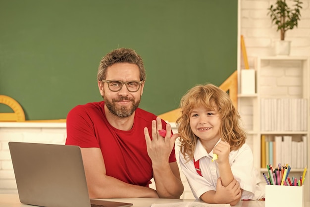 Online onderwijs op laptop vader en zoon gebruiken moderne communicatietechnologie