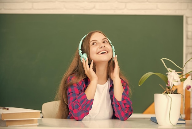 Online onderwijs terug naar school blij tienermeisje in koptelefoon muziekliefhebber