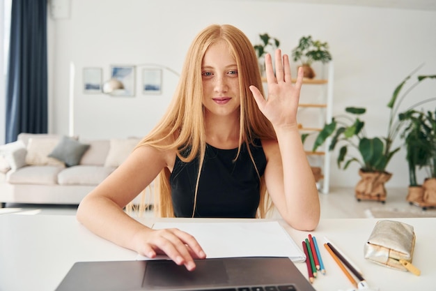 Online onderwijs Tienervrouw met blond haar is overdag thuis