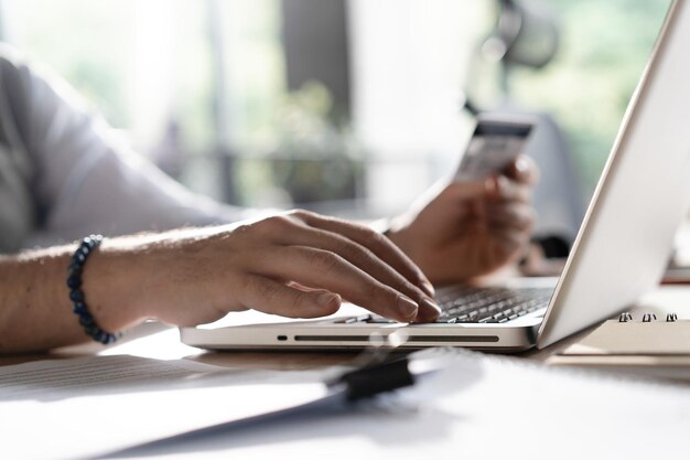 Online payment Man's hands holding a credit card and using smart phone for online shopping