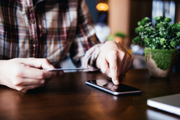 Online payment,Man's hands holding smartphone and using credit card for online shopping.