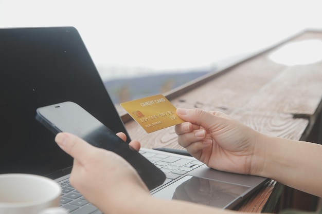 Photo online payment young woman holding credit card and touching on smartphone screen copy space