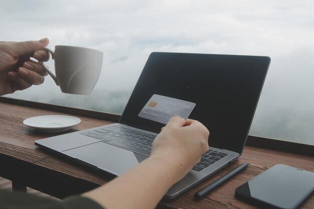 Photo online payment young woman holding credit card and touching on smartphone screen copy space