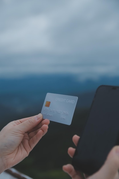 Photo online payment young woman holding credit card and typing on laptop