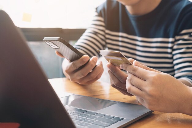 Photo online paymentmans hands holding smartphone and using credit card for online shopping cyber monday concept