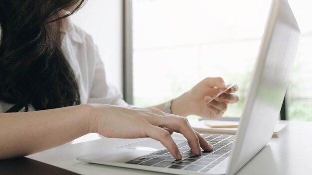 Photo online paymentyoung womans hands using credit card and computer laptop for online shopping black friday or cyber monday concept