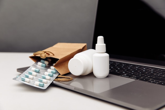Фото Концепция интернет-аптеки. белые контейнеры для макетов таблеток и спреев