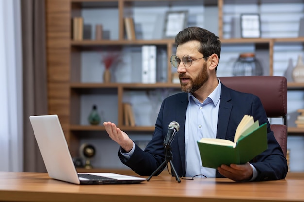 Online presentatie van het boek een jonge schrijver en auteur in een pak zit op kantoor aan een tafel in