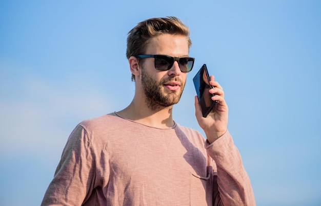 온라인 예약 생활의 현대 기술 항상 연락 사나이 남자는 휴대 전화를 사용합니다 자신감있는 남자는 전화로 이야기 친구에게 전화 섹시한 남자 하늘 배경 남자 캐주얼 스타일 패션 모델
