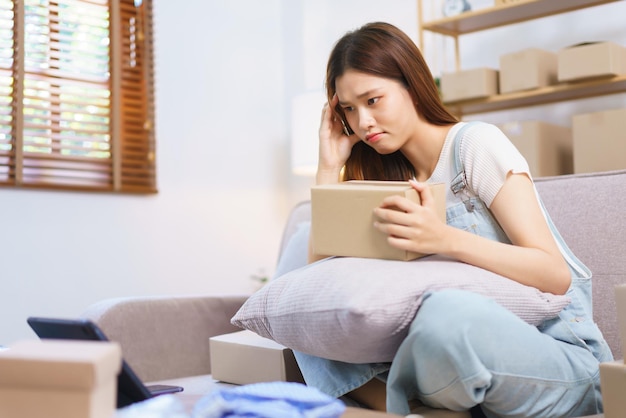 Online seller concept Female entrepreneur confused while reading data on tablet to write address