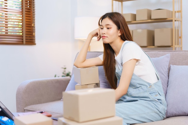 Online seller concept Female entrepreneur feel exhausted after packing product in box for shipping