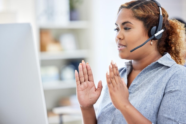 Seminario online seminario e riunione tenuti da un agente del call center che spiega la presa e la conversazione su un computer desktop mentre lavora in un ufficio donna che fornisce il servizio clienti