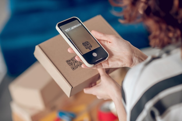 Photo online shop worker scanning information on the product package