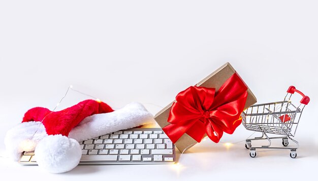 Online shoppen tijdens de kerstvakantie. Mooi cadeau in winkelwagen gekocht op internet. Online opslaan, met behulp van een computer. Kerst online concept tijdens quarantaine en lockdown