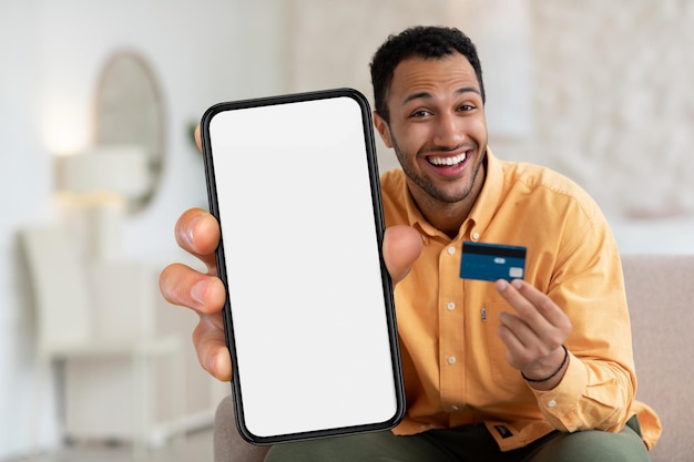 Online Shopping-app Opgewonden zwarte man met creditcard en lege smartphone