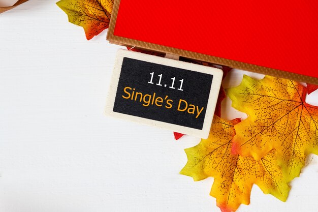 Acquisto in linea della cina, concetto di vendita di giorno del singolo 11.11. mini lavagna per testo e foglia d'acero con vendita di testo 11.11 single's day su sfondo bianco.