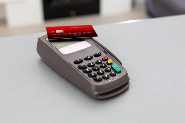 Online shopping concept. Close-up of a cash register next to a cart on a gray background, top view, copy space