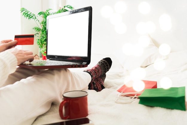 Фото Концепция онлайн-покупок с женщиной, держащей ноутбук и кредитную карту дома
