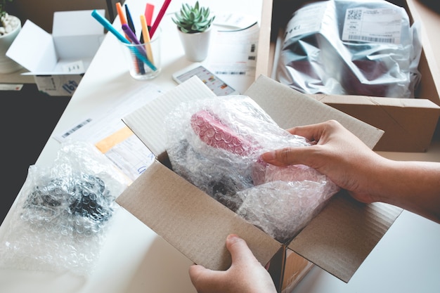 Online shopping concepts with female open box, presents some product in her hand