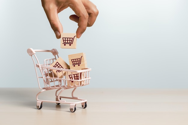Фото Концепция рынка доставки онлайн-покупок рука держит блок деревянных кубиков с иконками корзины для покупок в тележке для покупок продажа маркетинга покупка доставка