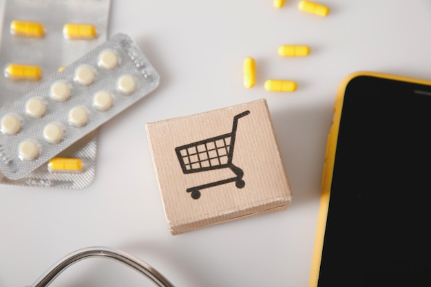 Online shopping drug delivery concept Card box with pills and smartphone on a table