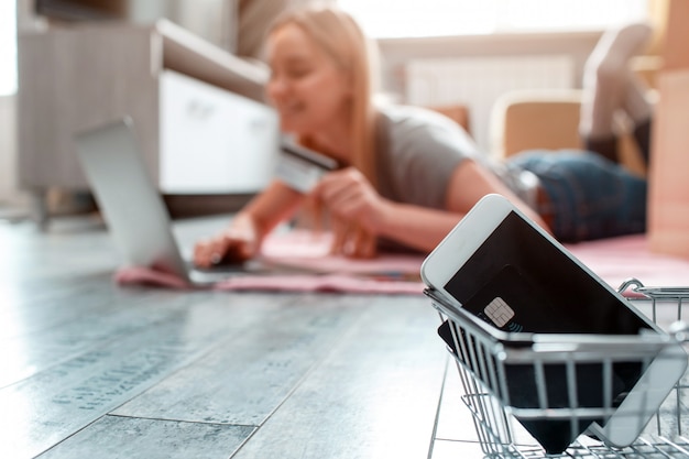 自宅でのオンラインショッピング。クレジットカードとスマートフォンは、ラップトップを持った買い物客の1日セールの準備ができています。