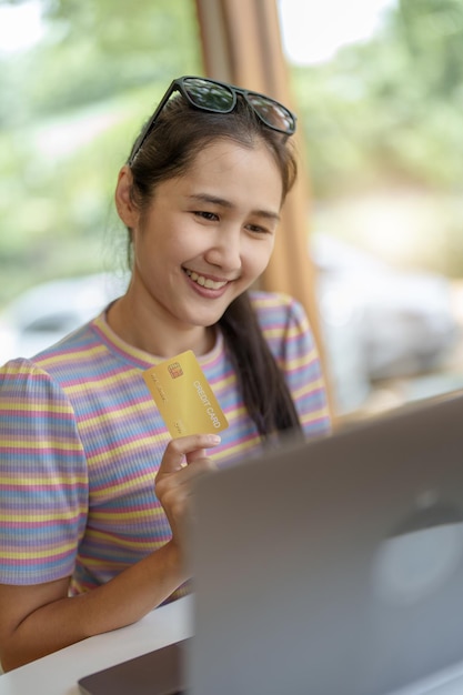 Photo online shopping and internet payments portrait of beautiful asian women are using their credit cards and mobile phones to shop online or conduct errands in the digital world