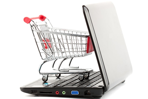 Online shopping. Shopping cart with notebook on the white.