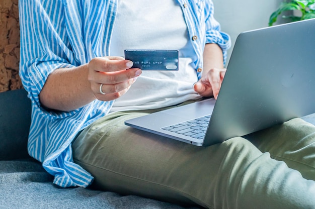 online shopping with a credit card girl sits on the bed at the computer in her hands