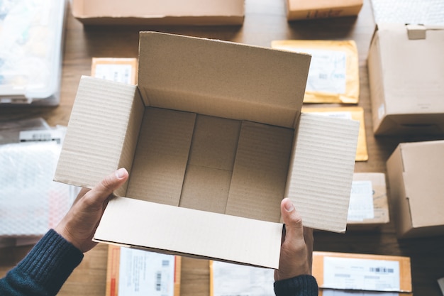 Online shopping with male hand holding brown box