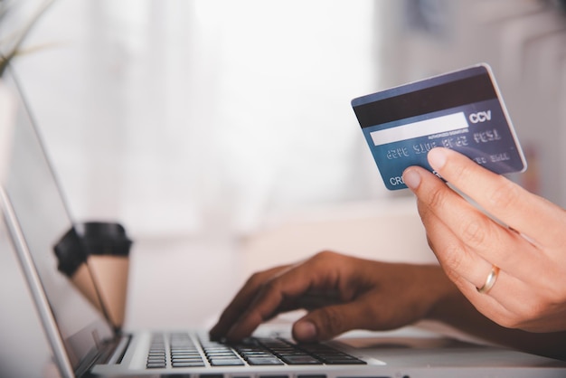 Online shopping Woman hands holding credit card and using laptop with product purchase at home female register via credit cards on computer to make electronic payment security online