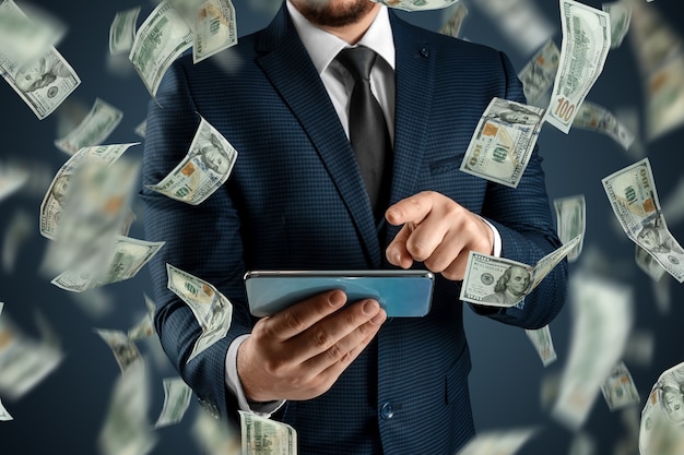 Scommesse sportive online. un uomo in giacca e cravatta sta tenendo uno smartphone e i dollari stanno cadendo dal cielo. background creativo, gioco d'azzardo.