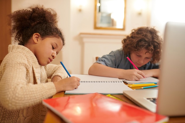 Photo online studying. a group of kids studying remotely together and writing something down